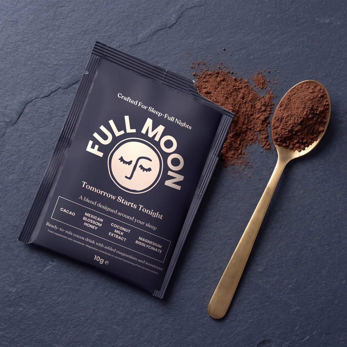 A Full Moon sachet with a spoonful of cacao powder beside it