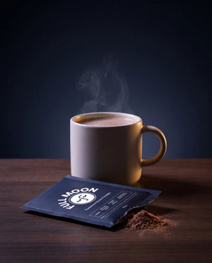 A mug of Full Moon hot cacao beside a torn sachet
